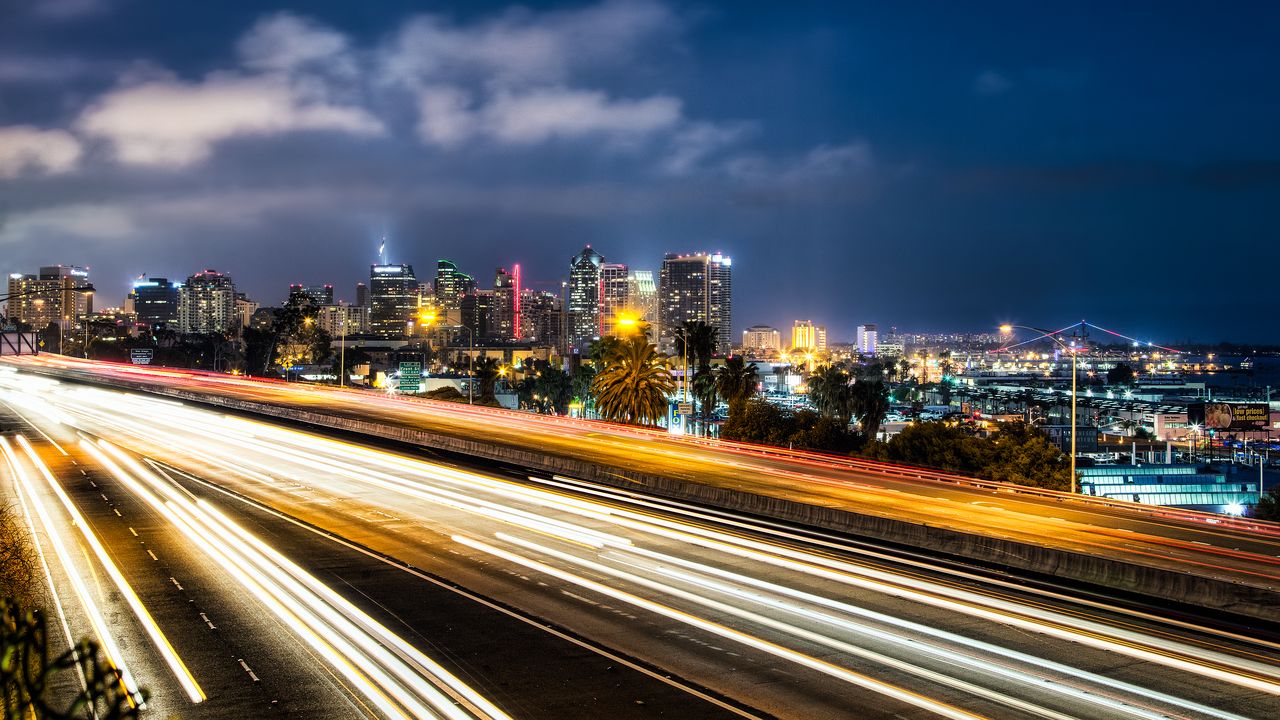 Freeway light trails heading toward the San Diego skyline at night